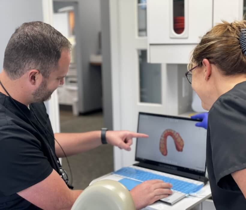 Dr. Hrencher reviewing a patient's dental x-rays with his hygienist